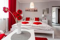 Un dormitorio con una cama con almohadas rojas y un jarrón con flores en Grey House, en Wroclaw