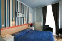 a bedroom with a blue bed and a desk and a chair at Hôtel Panoramic in Luchon