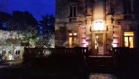 un bâtiment avec une lumière sur la porte la nuit dans l&#39;établissement Logis Hôtel Résidence Les Cèdres, à Villeneuve-lès-Avignon