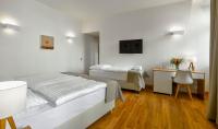 a bedroom with two beds and a table and a desk at Hotel Garden Court in Prague