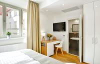 a bedroom with a bed and a desk and a tv at Hotel Garden Court in Prague