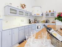 a kitchen with blue cabinets and a wooden table with wine glasses at Amazing Holiday Home in Cazals with Terrace in Cazals