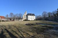 a large grass field with a castle in the background at Hotel Am Hohen Schwarm in Saalfeld