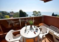 a white table and chairs on a balcony at Résidence &quot;Le Golfe Bleu&quot; in Roquebrune-Cap-Martin