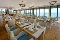 a restaurant with tables and chairs and windows at Alisios in Albufeira