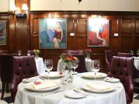 comedor con mesa, sillas y pinturas en Claridge Hotel, en Buenos Aires