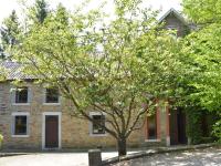 a brick house with a tree in front of it at This plain house is very suitable for groups in Ferrières