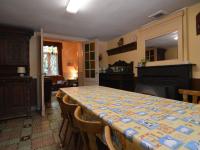 a dining room with a table with chairs and a fireplace at This plain house is very suitable for groups in Ferrières