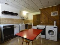 a kitchen with a table and a washing machine at This plain house is very suitable for groups in Ferrières