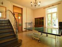 a room with a ping pong table and stairs at This plain house is very suitable for groups in Ferrières
