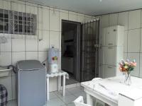 a kitchen with white tiled walls and a refrigerator at Casa com Piscina Paraty in Paraty