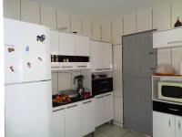 a kitchen with white cabinets and a white refrigerator at Casa com Piscina Paraty in Paraty