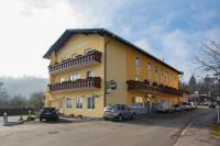 a yellow building with cars parked in a parking lot at Hotel Freiensteinerhof Superior in Sankt Peter-Freienstein