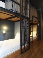 a bedroom with two bunk beds with white sheets at Silom Space Hostel in Bangkok