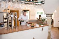 a woman standing in a kitchen pouring wine at Hotel Alt-Oberndorf in Oberndorf bei Salzburg