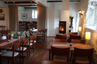 a restaurant with wooden tables and chairs and a fireplace at Hotel Stallbacken Nagu in Nauvo