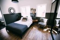 a small bedroom with a bed and two chairs at Noon on Sunset Hill in Los Angeles