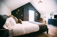 a bedroom with a large bed with a black wall at Noon on Sunset Hill in Los Angeles