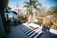 a deck with tables and chairs and an umbrella at Noon on Sunset Hill in Los Angeles