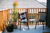 a porch with two chairs and potted plants at Noon on Sunset Hill in Los Angeles
