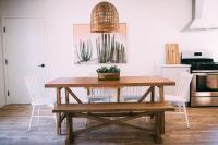 a dining room with a wooden table and white chairs at Noon on Sunset Hill in Los Angeles
