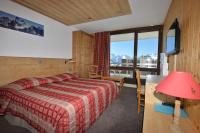 a bedroom with a bed and a large window at Hôtel Le Dôme in L&#39;Alpe-d&#39;Huez