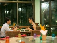 a man and woman sitting at a table in a restaurant at Maneechan Resort - SHA Extra Plus in Chanthaburi