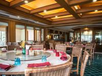 a dining room with tables and chairs with red napkins at Maneechan Resort - SHA Extra Plus in Chanthaburi