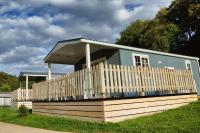 a small blue house with a wooden fence at Camping Bissen in Esch-sur-Sûre
