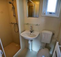 a bathroom with a sink and a toilet and a mirror at Camping Bissen in Esch-sur-Sûre