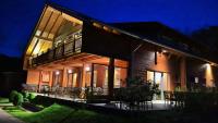 a house with tables and chairs in front of it at night at Camping Bissen in Esch-sur-Sûre