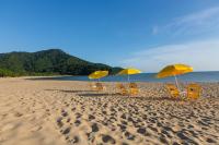 a group of chairs and umbrellas on a beach at Pousada DiMari in Boicucanga