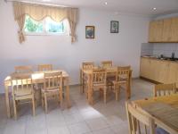 een keuken en eetkamer met houten tafels en stoelen bij House Magdic Plitvice in Grabovac