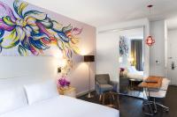 a hotel room with a bed and a bedroom with a painting on the wall at NU Hotel in Brooklyn