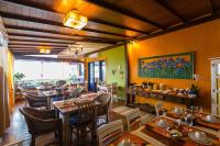 a restaurant with tables and chairs and a painting on the wall at Pousada DiMari in Boicucanga
