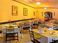 a restaurant with tables and chairs with yellow walls at Hotel Yanuncay in Cuenca