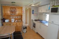 a kitchen with white appliances and a table in it at Lac de la Vie in Bressuire