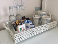 a shelf with bottles and cups and other items on it at Shellseekers Guest House in Looe