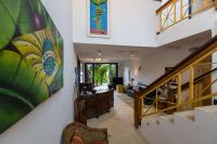 a hallway with a staircase and a living room at Pousada DiMari in Boicucanga