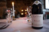 Una botella de vino sobre una mesa con copas. en Port Charlotte Hotel, en Port Charlotte