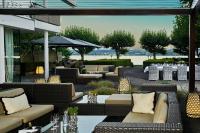 Un patio con sofás, mesas y sillas. en RIVA - Das Hotel am Bodensee, en Constanza
