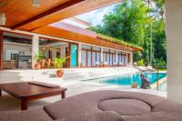 Una sala de estar con piscina y una casa. en Villa Merdu Ubud, en Ubud