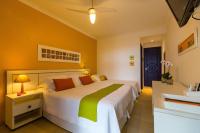 a bedroom with a large white bed and a sink at Pousada DiMari in Boicucanga