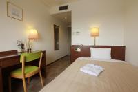 Una habitación de hotel con una cama, una silla y un escritorio. en Kumegawa Wing Hotel, en Higashi-murayama