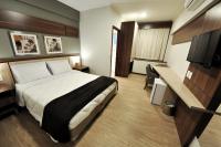 a hotel room with a bed and a desk at Klein Ville São Leopoldo in São Leopoldo