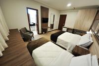 a hotel room with two beds and a desk at Klein Ville São Leopoldo in São Leopoldo