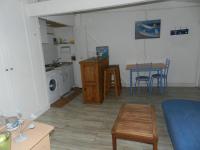 a living room with a kitchen and a table with chairs at Appartement vue sur le port de Dieppe in Dieppe