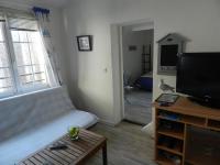 a living room with a couch and a flat screen tv at Appartement vue sur le port de Dieppe in Dieppe