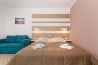 ein Schlafzimmer mit einem Bett und einer blauen Couch in der Unterkunft Willa Arielka in Rewal