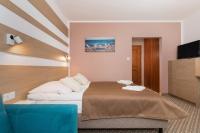 ein Hotelzimmer mit einem Bett und einer blauen Couch in der Unterkunft Willa Arielka in Rewal